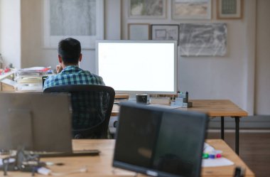 Dikiz geç bir ofiste çalışırken masasında bir bilgisayar kullanarak bir genç Tasarımcısı 