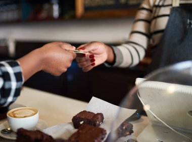 Ellerin onun cappuccino için ödemek için bir kahve dükkanı kasiyer banka kartını veren bir kadın Afrika müşterinin portre resim