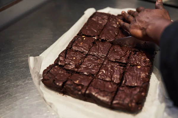 Closeup Baker Cutting Freshly Made Brownies Squares While Working Counter — Stock Photo, Image