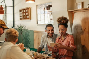 Gülümseyen genç kadın arkadaşı resimler birlikte arkadaşlarıyla bir barda otururken bir cep telefonu üzerinde gösterilen