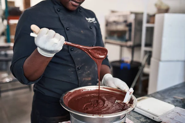 Close Van Een Werknemer Een Lepel Gesmolten Chocolade Vol Houden — Stockfoto