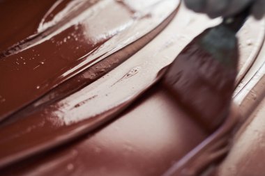 Çikolata Fabrikası zanaat bir çikolata içinde çalışırken soğutmak için dışarı erime yayılan bir işçi closeup