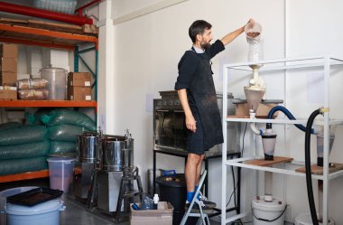 Hazretleri ve kabukları zanaat bir çikolata fabrikası içinde merdiven dururken ayırmak için girişimci bir makinenin içine kakao çekirdekleri dökme