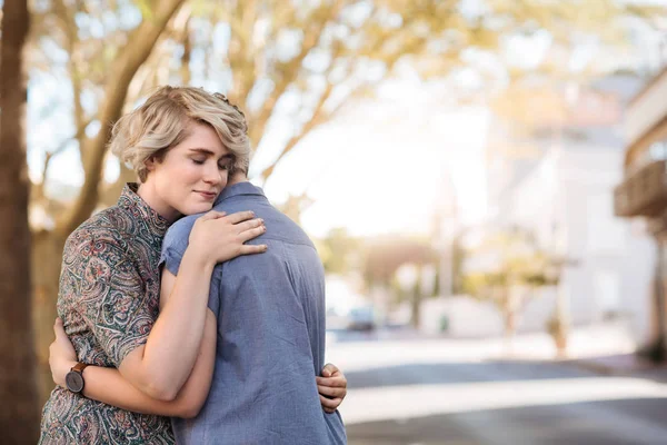 晴れた日に街に一緒に立ったまま抱きしめる愛情の若いレズビアンのカップル — ストック写真