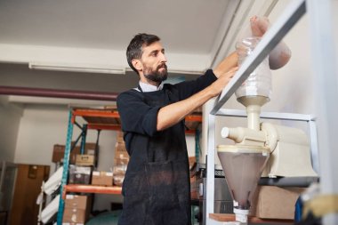 Küçük işletme sahibi bir zanaat çikolata kakao çekirdekleri bir makinenin içine dökme fabrika içinde Hazretleri ve kabukları ayırmak için