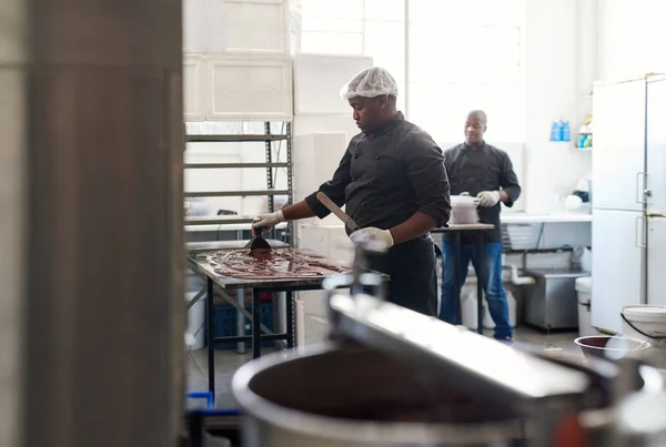 Работник Малого Бизнеса Африки Распространяет Расплавленный Шоколад Охладить Работая Фабрике — стоковое фото
