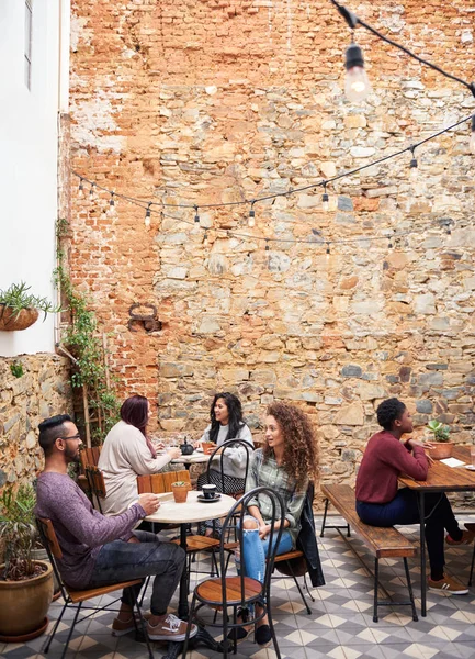 Diverso Grupo Jovens Conversando Sobre Café Enquanto Sentados Juntos Mesas — Fotografia de Stock