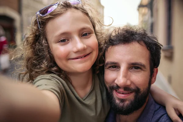 父と幼い息子笑みを浮かべて 市内で 日を楽しみながら一緒に Selfies を取る — ストック写真