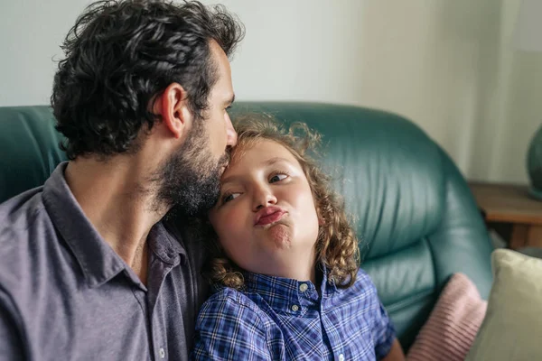 自宅のリビング ルームのソファに一緒に座って額に彼の若い息子 愛情のこもったキスを与える単一のお父さん — ストック写真