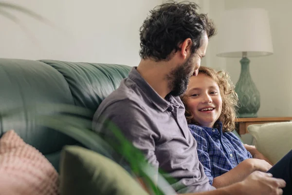 Lindo Niño Hablando Con Padre Mientras Están Sentados Juntos Sofá — Foto de Stock