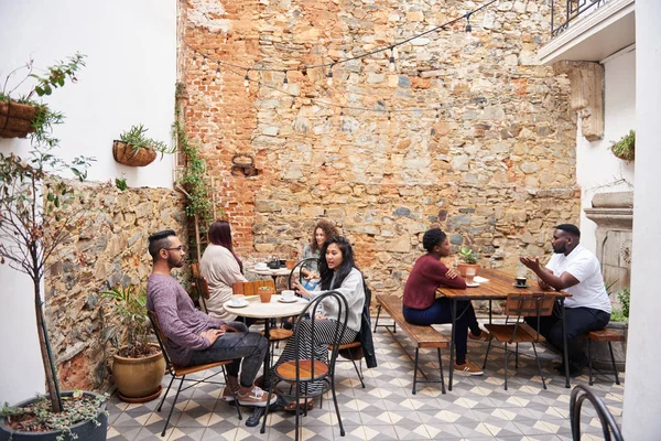 Diverso Grupo Jóvenes Tomando Café Charlando Mientras Sientan Juntos Las — Foto de Stock