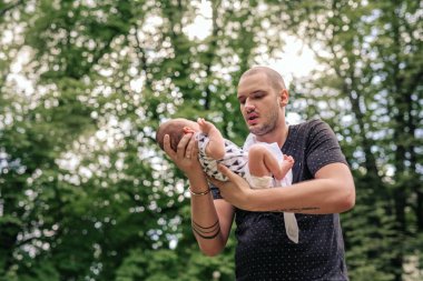 Onun bebek çocuk dışarıda duran bir parkta elinde kucaklarken genç babası olmakla gurur duyuyorum