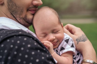 Genç bir baba onun bebek çocuk dışarıda duran bir parkta onun omzuna kucaklarken closeup