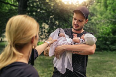 Sevgi dolu genç baba ve Anne orada çok güzel sarma bir battaniye ile bir parkta bir aile günün tadını çıkarırken bebeğim