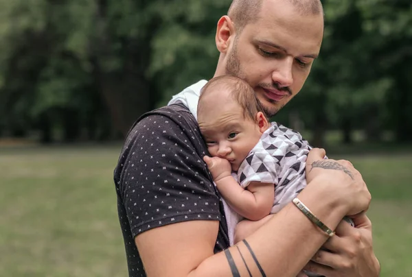 公園の外に立っている間彼の肩に男の愛らしい赤ちゃんをあやし愛する若い父親のクローズ アップ — ストック写真