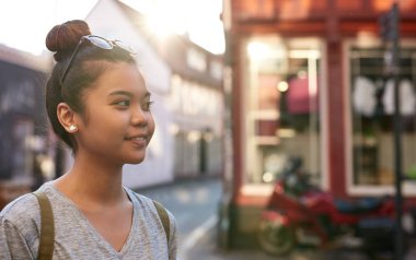Bir öğleden sonra şehirde yürüyüş harcama gülümseyen Genç Asyalı kadın kayıtsızca giyinmiş