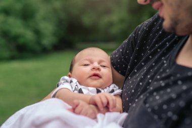 Onun şirin bebek çocuk kollarını bir parkta dışında dururken üzerinde tutan bir genç baba closeup