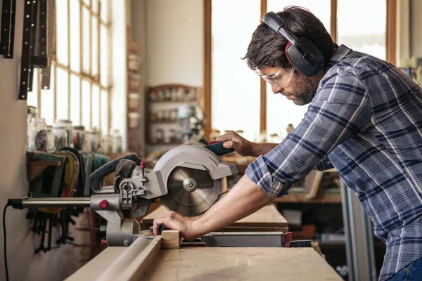 Wykwalifikowanych Woodworker Noszenia Narzędzi Bezpieczeństwa Pomocą Mitre Piły Cięcia Kawałek — Zdjęcie stockowe
