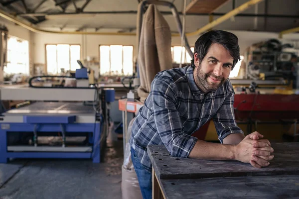 Retrato Carpintero Sonriente Apoyado Banco Trabajo Gran Estudio Carpintería Lleno —  Fotos de Stock