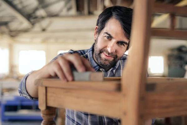 Closeup Smiling Woodworker Using Sandpaper Sand Wooden Chair While Working — Stock Photo, Image