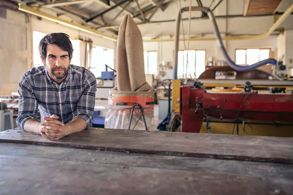 Focused Young Woodworker Looking Deep Thought While Leaning Workbench His — Stock Photo, Image