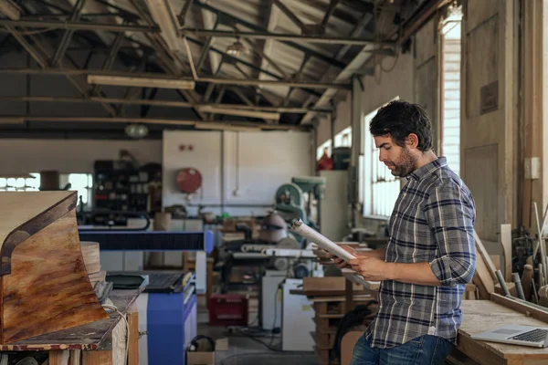 Joven Carpintero Apoyado Banco Trabajo Estudio Carpintería Leyendo Través Cuaderno — Foto de Stock