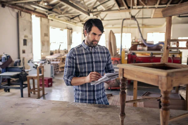 Woodworker Stående Stol Arbetsbänk Hans Snickeriverkstad Läsning Över Mönster Anteckningsbok — Stockfoto