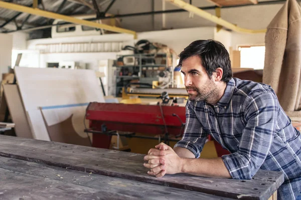Closeup Woodworker Looking Deep Thought While Leaning Workbench His Large — Stock Photo, Image