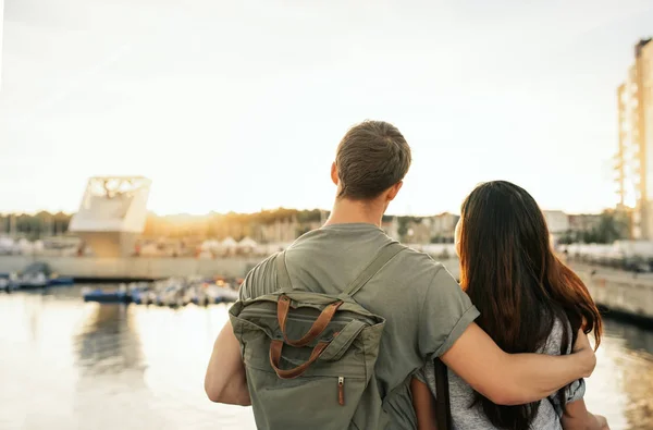 若いカップルに立って腕を組んで一緒に午後遅くに港を見渡せるのバックミラー — ストック写真