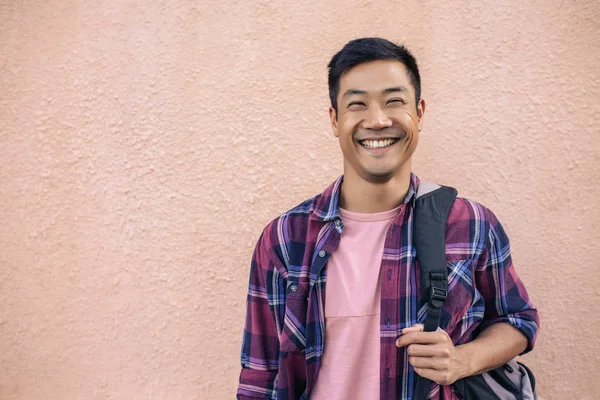Retrato Joven Asiático Sonriente Parado Frente Una Pared Afuera Llevando —  Fotos de Stock
