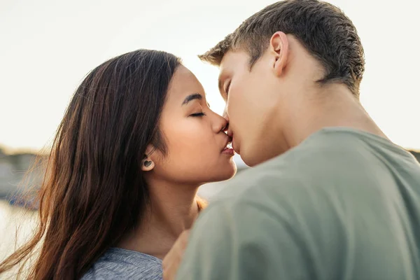 Romántica Pareja Joven Besándose Mientras Están Pie Brazo Brazo Juntos — Foto de Stock