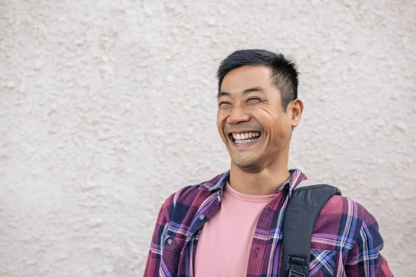 Lachen Jonge Aziatische Man Met Een Rugzak Staande Voor Een — Stockfoto