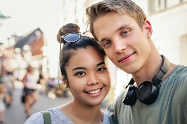 Mutlu genç çift ayakta kol kola şehrin bir sokakta portresi kapatın