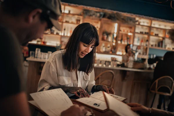 Dos Jóvenes Amigos Sentados Juntos Mesa Bar Por Noche Leyendo — Foto de Stock