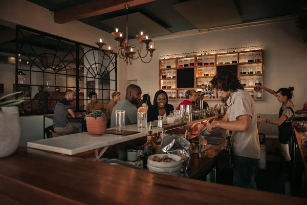 Akşam Içkiler Bar Sayaç Otururken Bir Barmen Ile Konuşan Genç — Stok fotoğraf