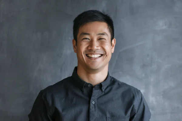 Uzavřete Portrét Usmívajícího Mladého Asijského Obchodníka Stojícího Před Prázdným Chalup — Stock fotografie