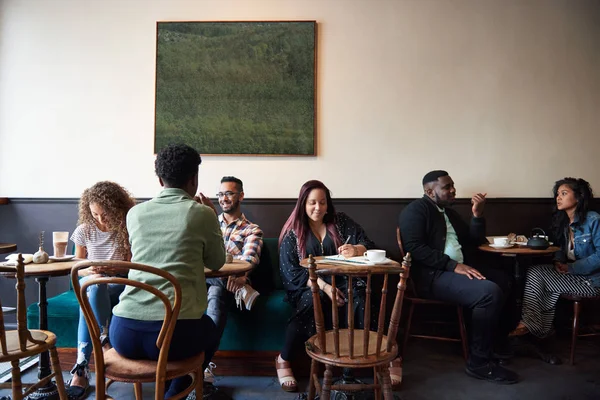 Grupo Jóvenes Diversos Sentados Mesas Café Moda Hablando Juntos Tomando —  Fotos de Stock