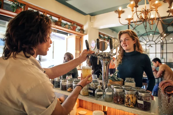 Jovem Barman Masculino Derramando Uma Cerveja Conversando Com Cliente Balcão — Fotografia de Stock