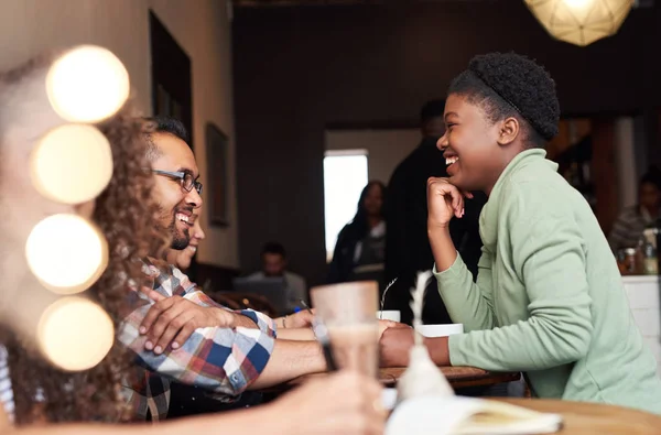 年轻的非洲裔美国妇女坐在咖啡馆里喝咖啡和和朋友在一起时大笑 — 图库照片
