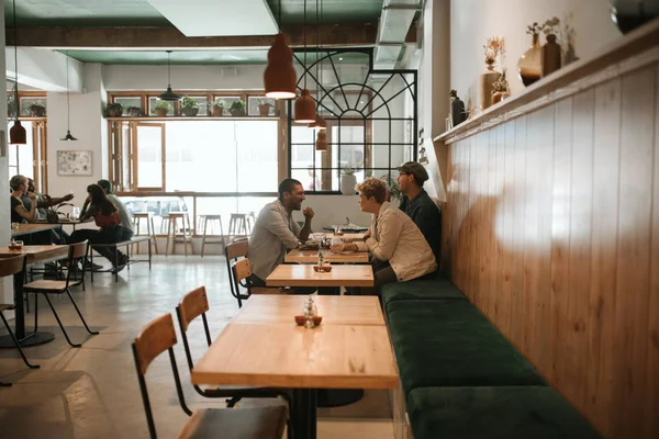 Diverso Grupo Jóvenes Amigos Sonrientes Hablando Durante Almuerzo Bebidas Juntos — Foto de Stock