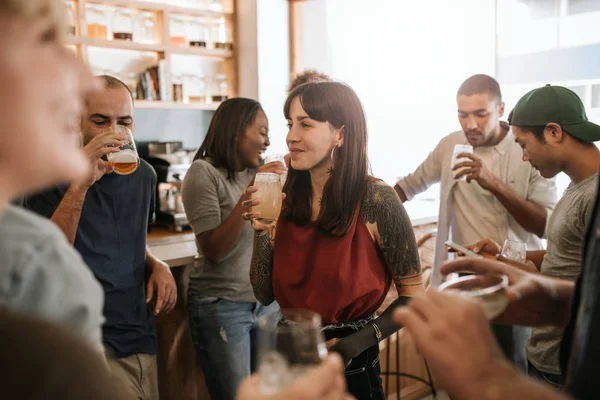 Mujer Joven Sonriente Pie Bar Hablando Con Grupo Diverso Amigos —  Fotos de Stock