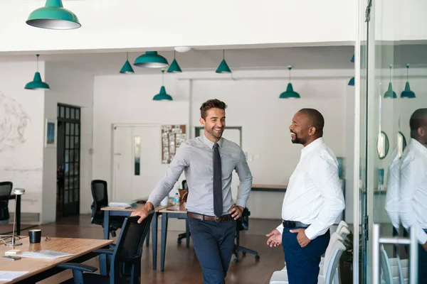 Двоє Молодих Бізнесменів Спілкуються Сміються Разом Стоячи Великому Сучасному Офісі — стокове фото