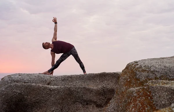 Fitter Mann Dreieck Pose Während Yoga Auf Felsen Meer Vor — Stockfoto