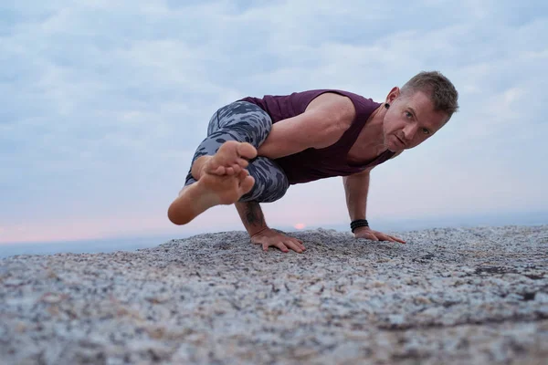 Fit Man Doing Eight Angle Pose While Practicing Yoga Rock — Stock Photo, Image