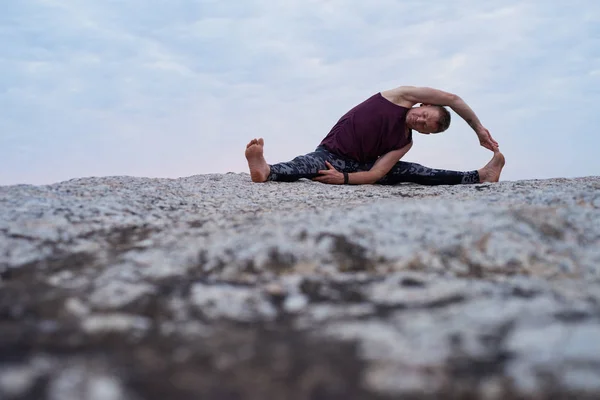 Fitter Mann Beim Drehen Von Kopf Bis Knie Während Yoga — Stockfoto