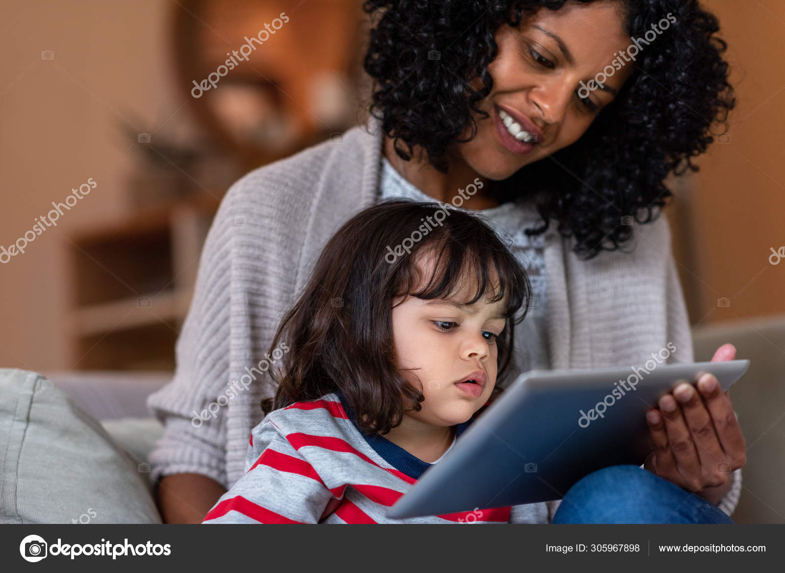 menina bonitinha sentada no chão usando tablet digital tocando a