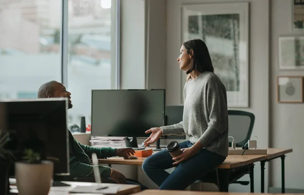 女设计师在办公室休息时喝咖啡 在办公室休息时在办公桌前与一位男同事交谈 — 图库照片