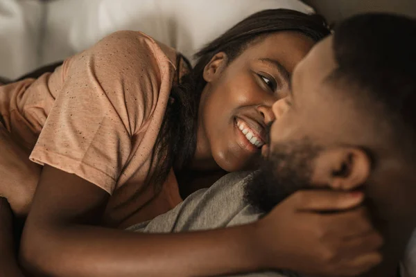 Ласкавий Молодий Афроамериканець Жінка Посміхається Обіймаючи Чоловіка Лежачи Ліжку Разом — стокове фото