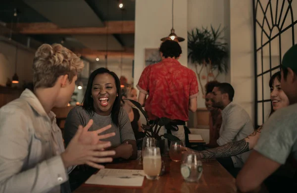 Diverso Grupo Jovens Amigos Rindo Enquanto Bebem Conversam Juntos Bar — Fotografia de Stock