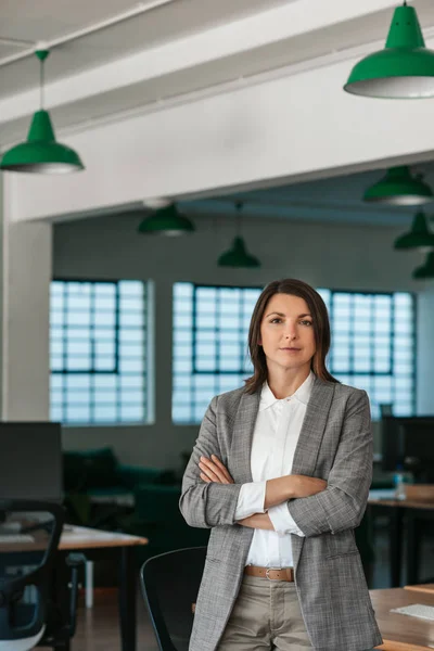 Portrait Confident Businesswoman Standing Her Arms Crossed Large Modern Office — ストック写真